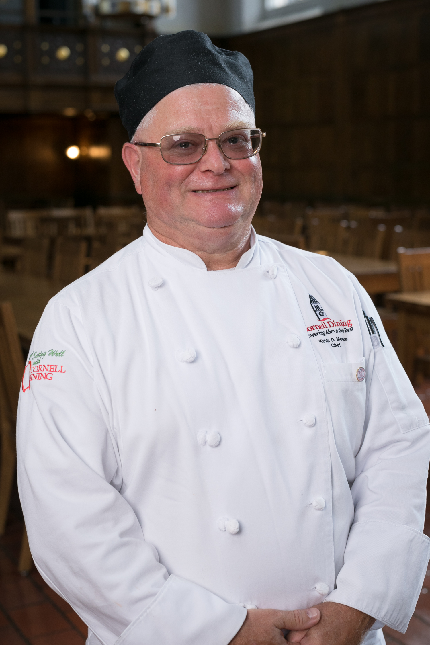 Chef Kevin Moore in white chef jacket and black hat, smiling