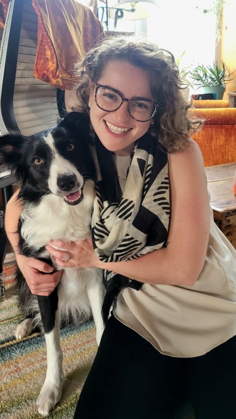 Amanda wearing glasses, in black and white, along with her dog, a border collie