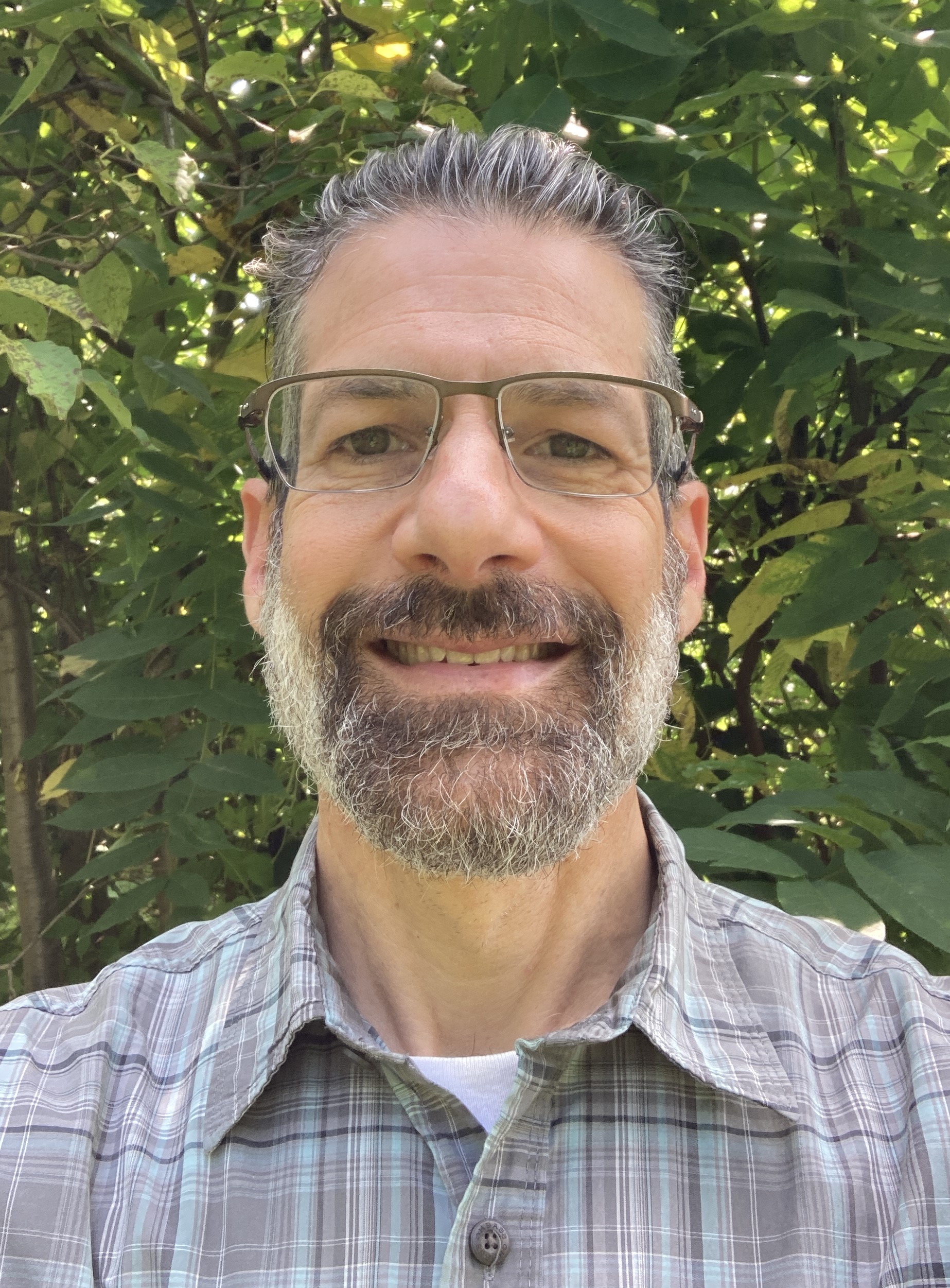 image of a man with a salt and pepper beard, smiling outside